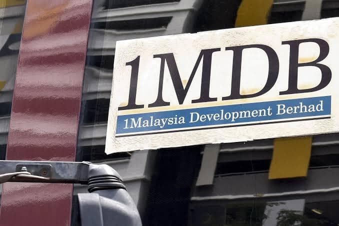 1MDB Malaysia signage on building wall reading "1Malaysia Development Berhad, Forging Partnerships, Advancing Growth"