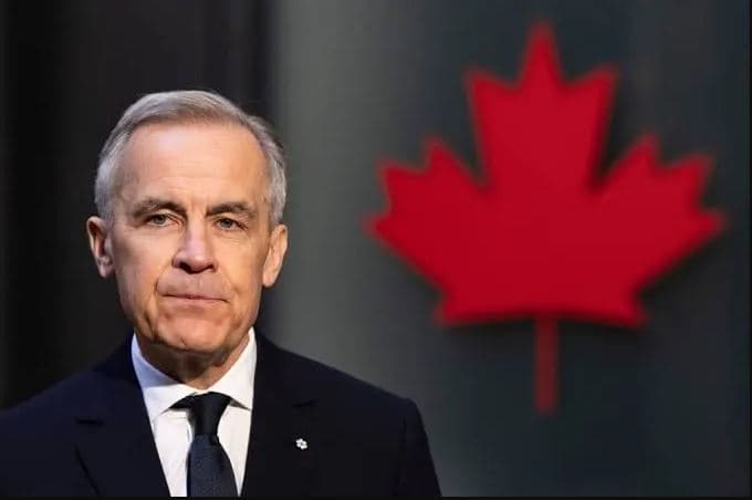 Mark Carney standing in a formal suit with a blurred Canadian flag in the background, symbolizing his leadership as Canada’s Prime Minister